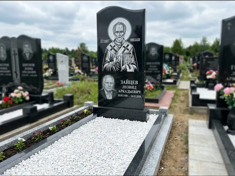 Памятник с гравировкой иконы: стела с крестообразным навершием — икона в резной рамке-киоте, газон без ограды, стриженая трава, работа «Раевская» в Казани