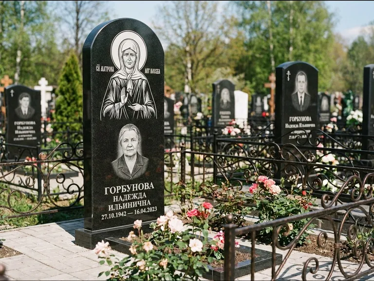 Памятник с гравировкой иконы: стела с арочным верхом и киотом под образ — гравировка образа Матроны Московской, гранитный цоколь с тёмной плиткой, работа «Ковалёв» в Казани