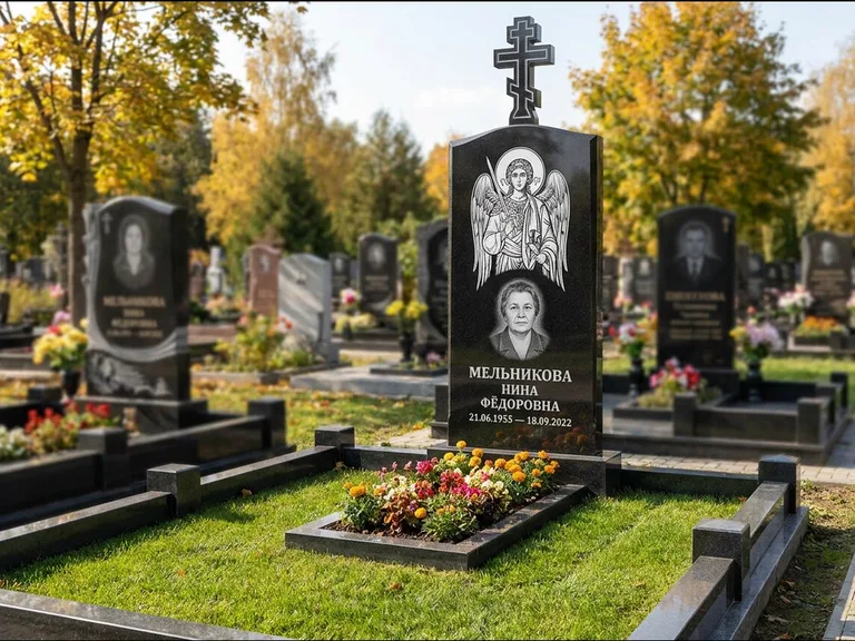 Памятник с гравировкой иконы: округлая стела-медальон с ликом — гравировка Богородицы «Семистрельная», луговые травы и полевые цветы за участком, работа «Гущин» в Казани