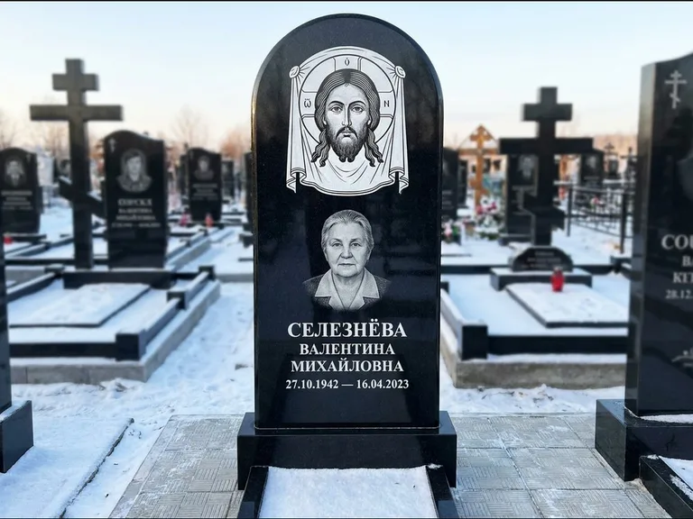 Памятник с гравировкой иконы: небольшая скромная одиночная стела с именной иконой — золочёный нимб на образе, аккуратный участок с газоном, работа «Ковалёв» в Казани