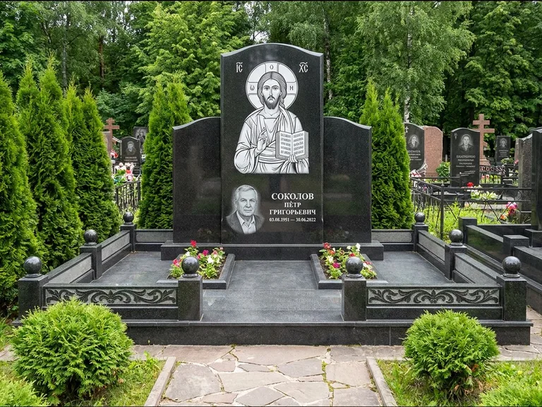 Памятник с гравировкой иконы: широкая горизонтальная лежачая плита-стела — икона в резной рамке-киоте, серая гравийная отсыпка с бордюром, работа «Богданова» в Казани