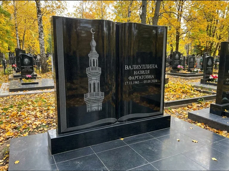 Мусульманский памятник с гравировкой мечети: стела в форме раскрытой книги на подставке — белая гравировка силуэта мечети с минаретами, цоколь тёмной плиткой, работа «Исмаилова» в Казани