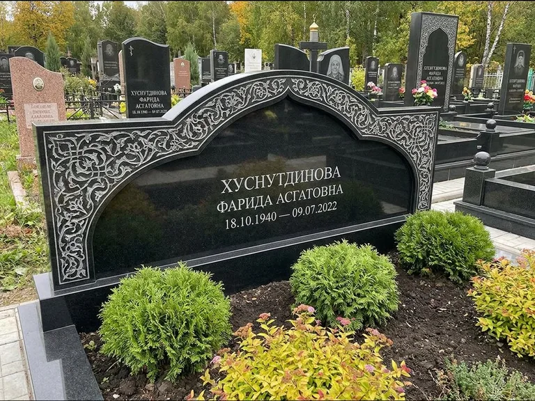 Мусульманский памятник: вытянутая горизонтальная семейная стела с аркой — белая гравировка силуэта мечети с минаретами, участок с декоративными кустами, работа «Зарипова» в Казани
