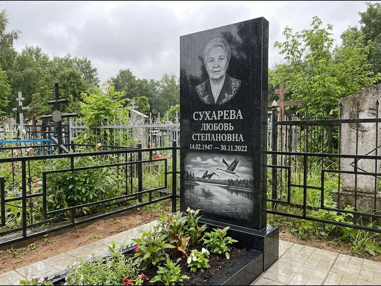 Памятник с гравировкой журавлей — гравировка пары журавлей над гладью озера в нижней части, работа «Сухарева» в Казани