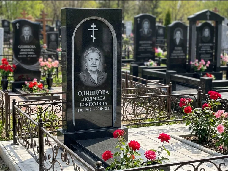 Памятник из чёрного гранита — скромная невысокая стела с крестом с терновым венцом, работа «Лаврентьева» в Казани