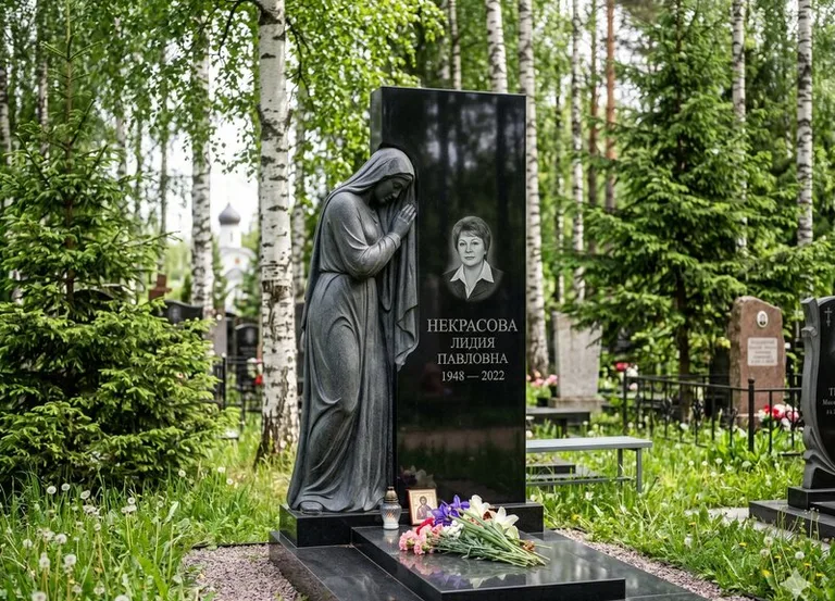 Гранитная фигура скорбящего мужчины у чёрной стелы в Казани